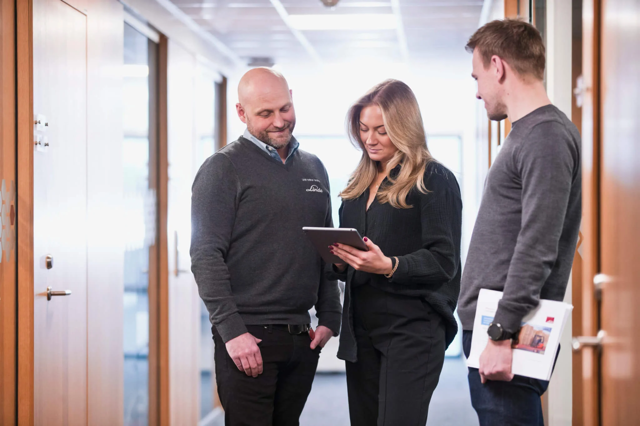 Anställda hos Linde Material handling, en del av KION Group, diskuterar utbildningen framför en iPad.